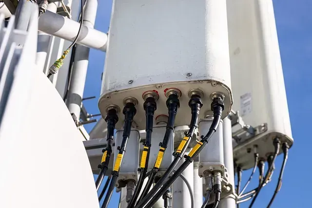 Un primer plano de una torre con muchos cables saliendo de ella.