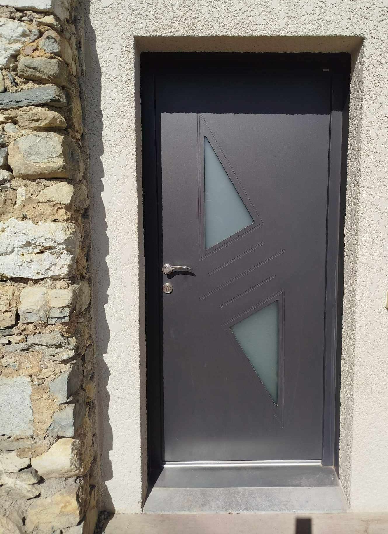 Une porte d'entrée grise en aluminium
