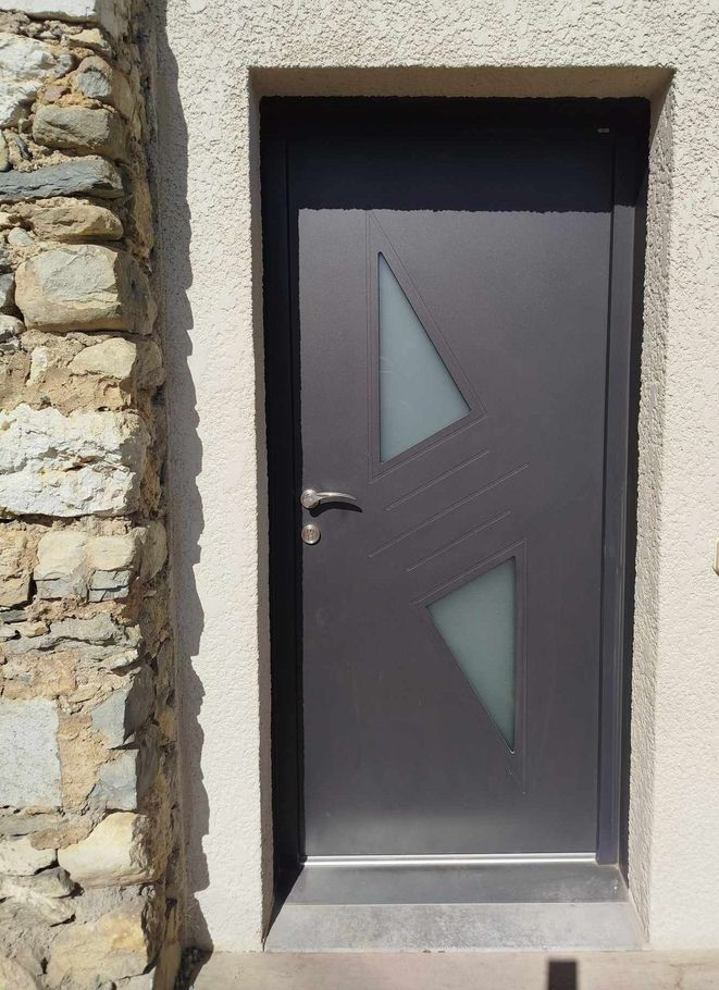 Une porte d'entrée grise en aluminium