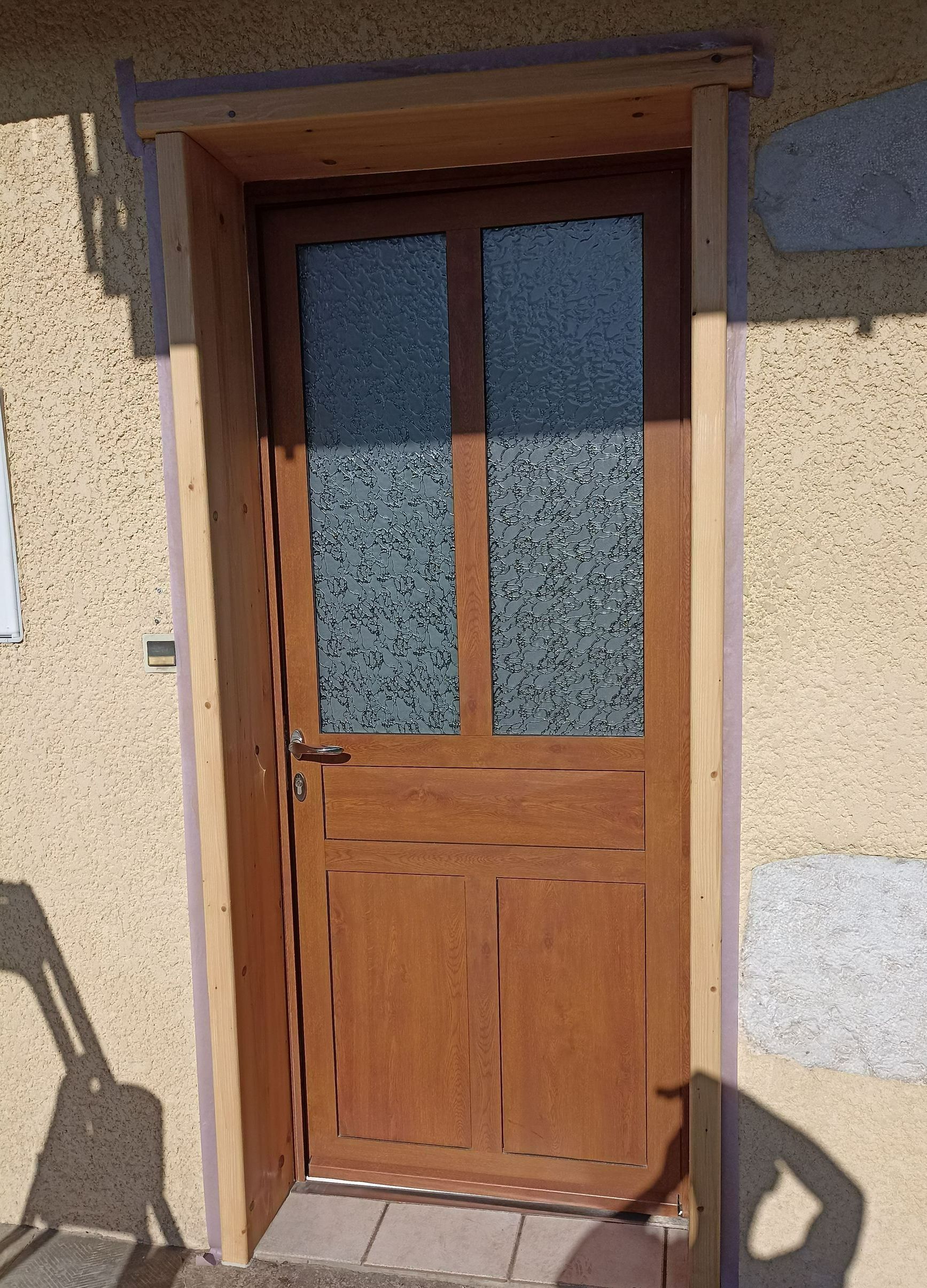 Une porte d'entrée en bois et vitrée