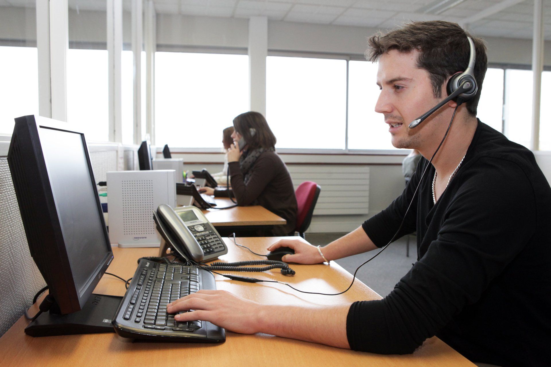 Homme vu de profil avec deux femmes en arrière-plan
