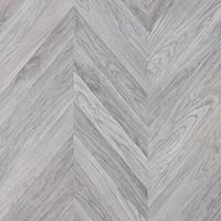 Un primer plano de un piso de madera gris con un patrón de espiga.