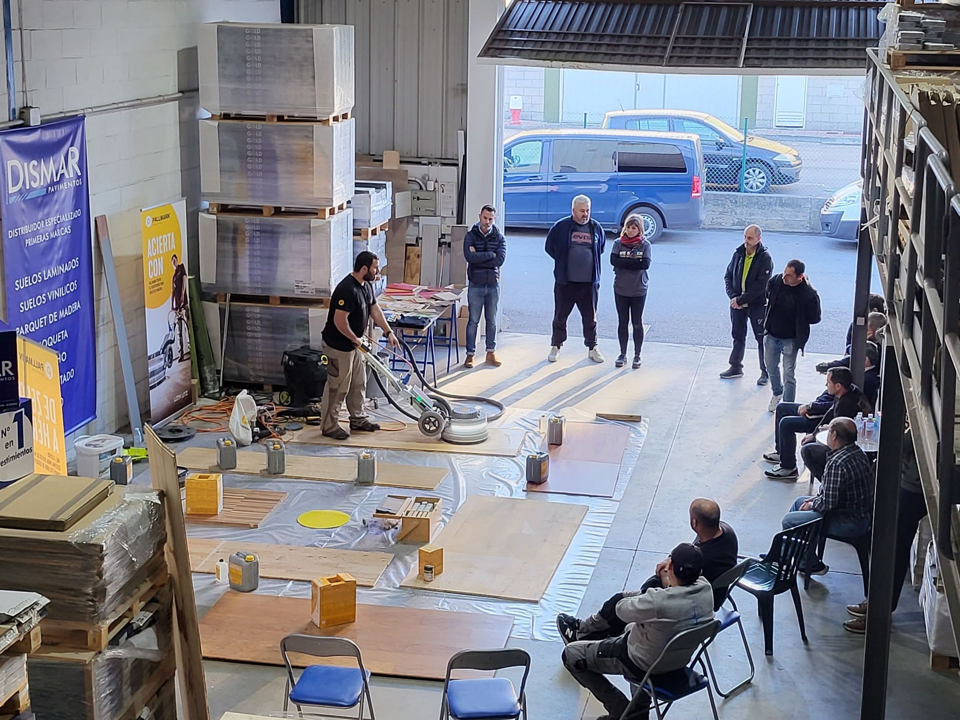 Un grupo de personas están de pie y sentadas en un almacén.
