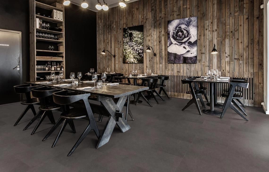 Suelo rectangular de color gris oscuro, con diseño similar al ladrillo.