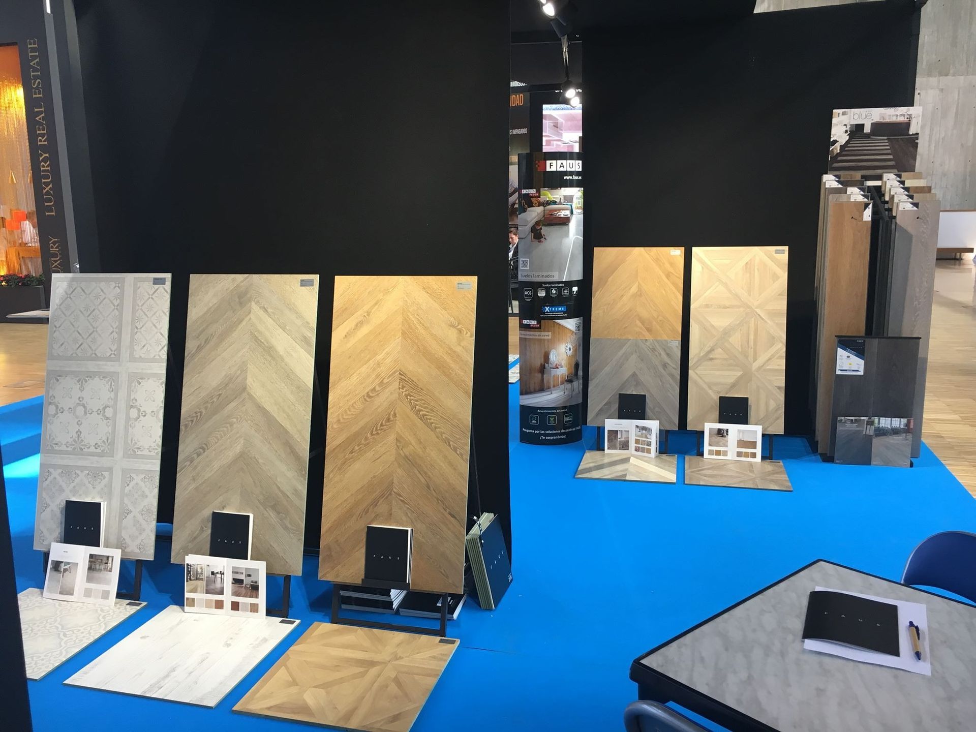 Una exhibición de diferentes tipos de pisos de madera sobre una alfombra azul.