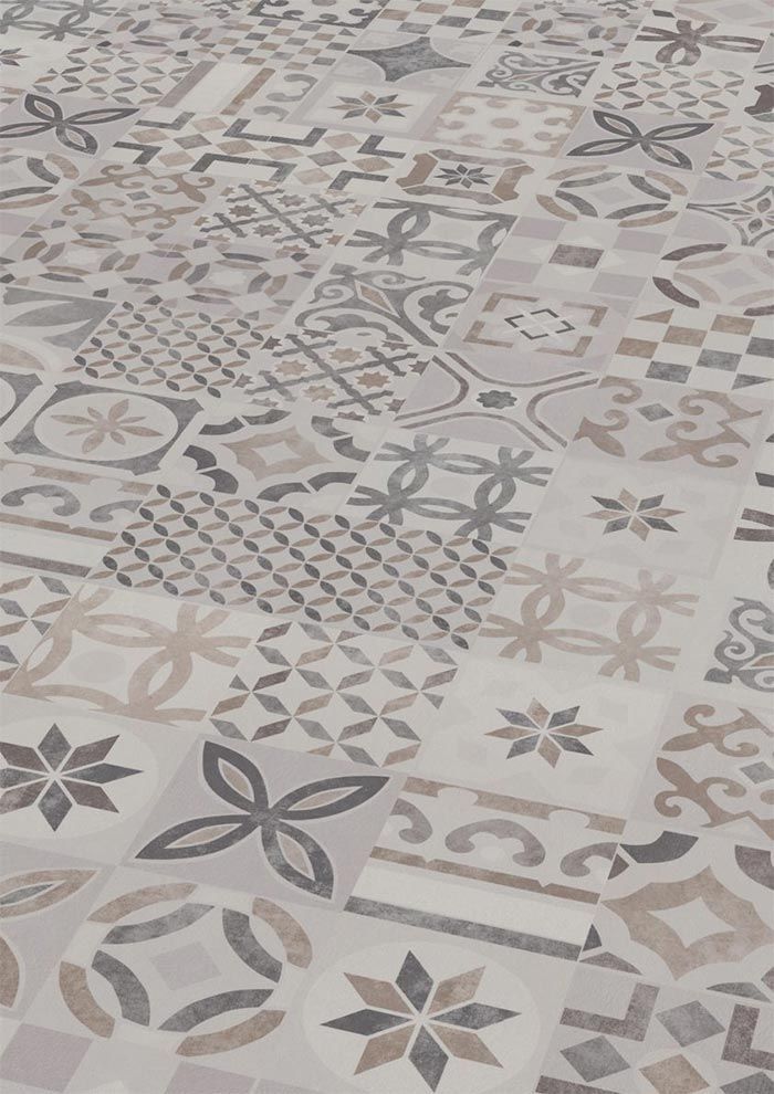 Superficie revestida con una variedad de azulejos cuadrados con patrones en tonos beige, gris y marrón.