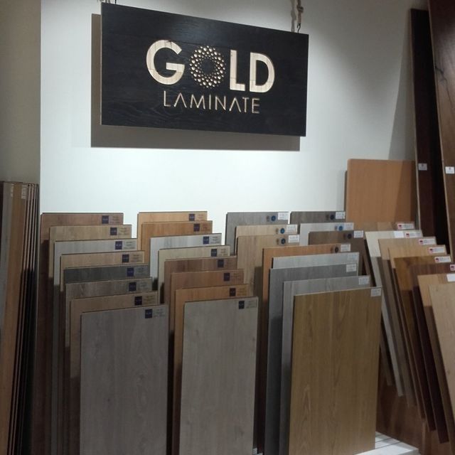 Un letrero laminado en oro cuelga sobre una exhibición de madera.