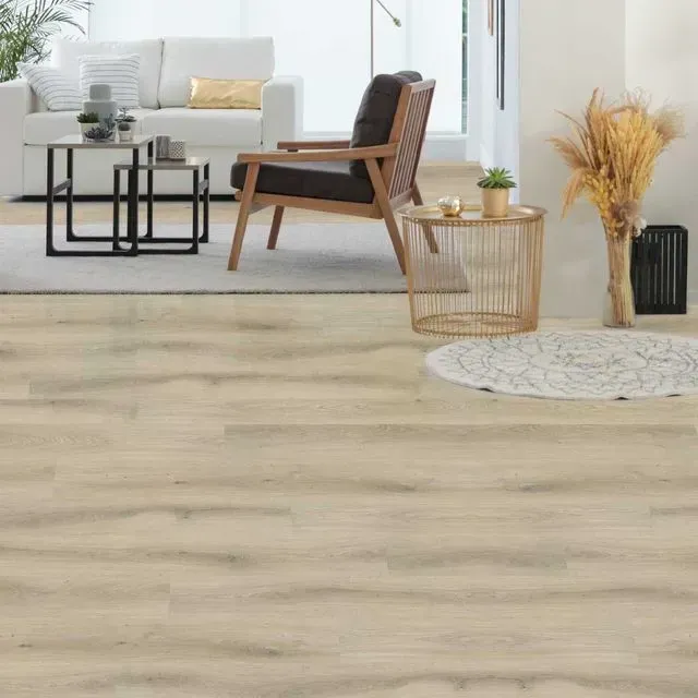 Una sala de estar con sofá, silla, mesa y alfombra.