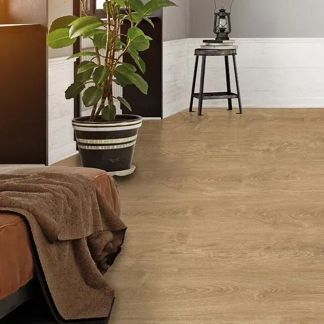 Un dormitorio con pisos de madera y una planta en una maceta.