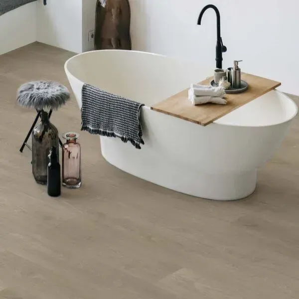 Una bañera está colocada sobre una mesa de madera en un baño.
