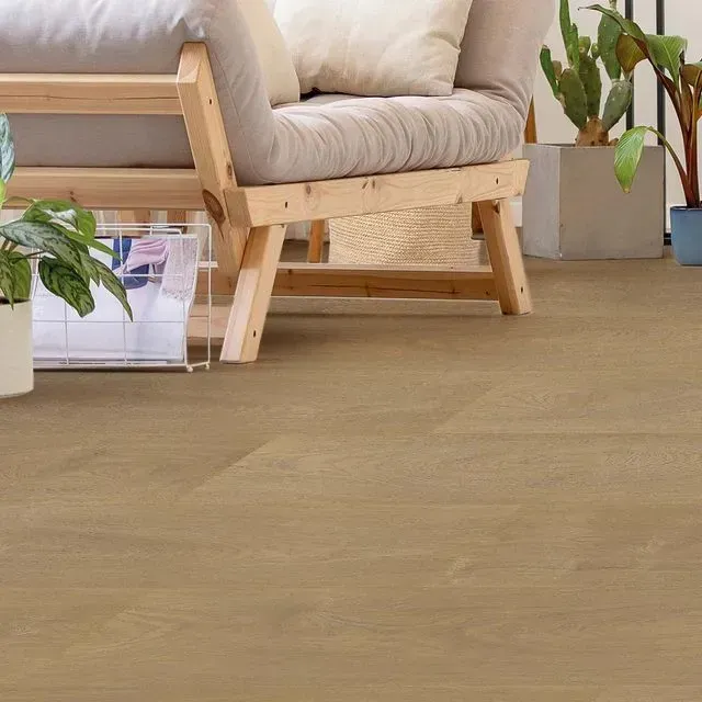 Una sala de estar con una silla de madera, un sofá y plantas en macetas.