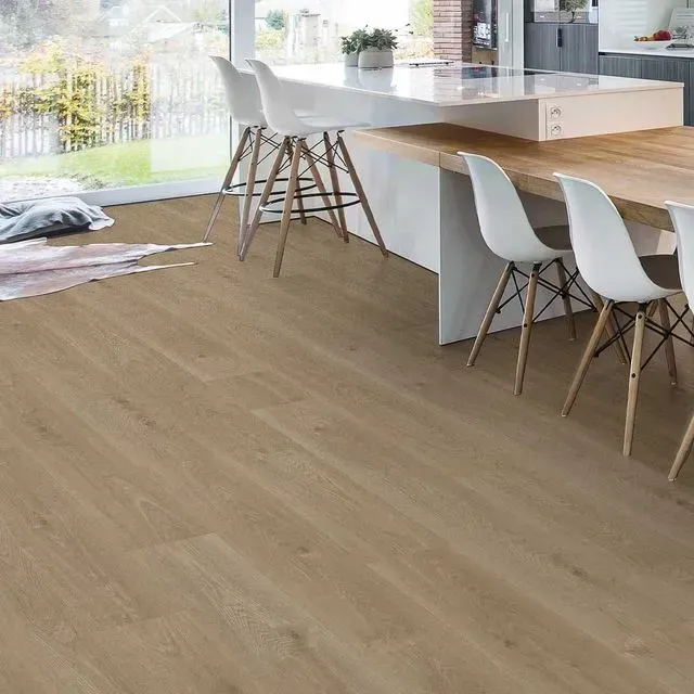 Una cocina con suelo de madera, mesa y sillas.