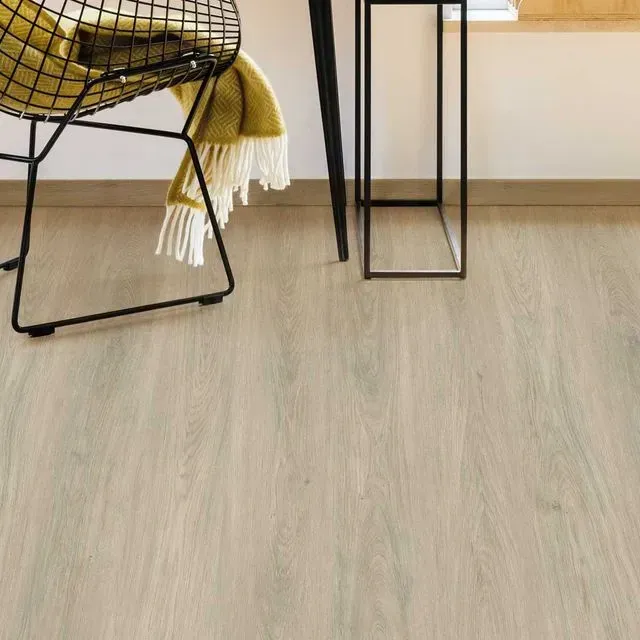 Una silla está colocada sobre un suelo de madera al lado de una mesa.