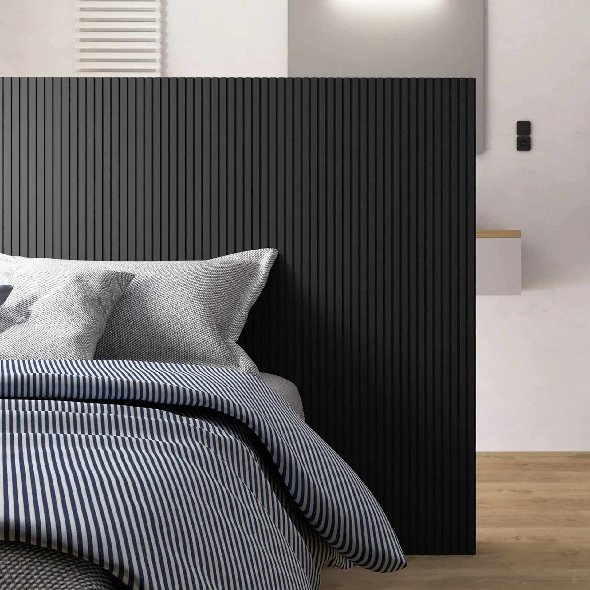 Una cama con un edredón de rayas y almohadas en un dormitorio con cabecera negra.