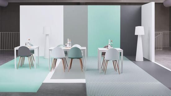 Una habitación con mesas y sillas y una alfombra en el suelo.