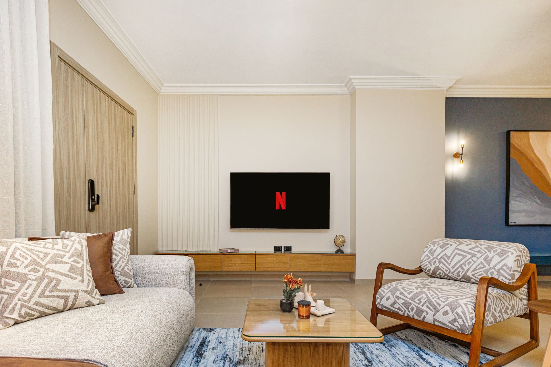 A living room with a couch , chair , coffee table and television.
