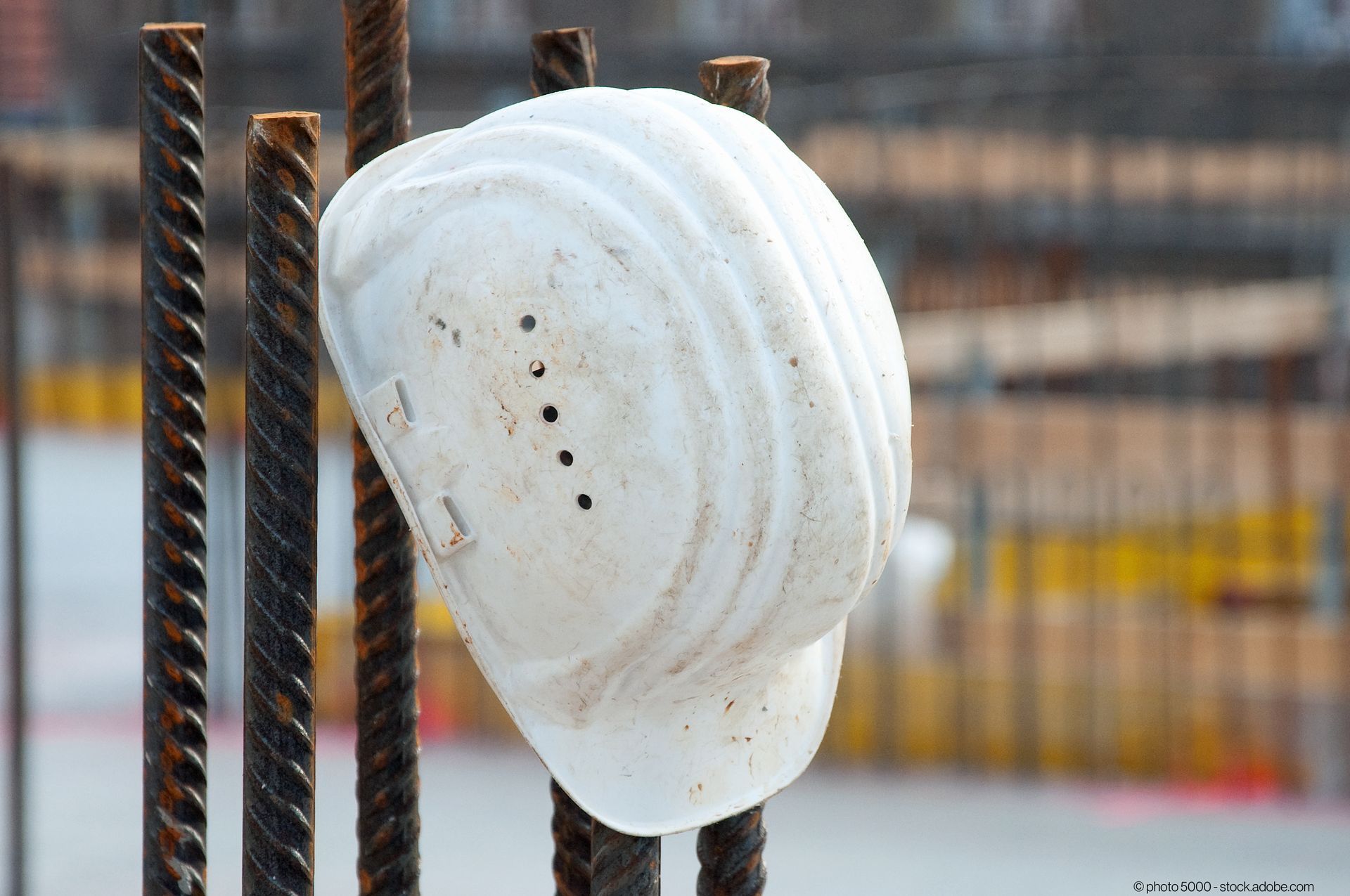 Bauarbeiterhelm hängt an Stahlstangen