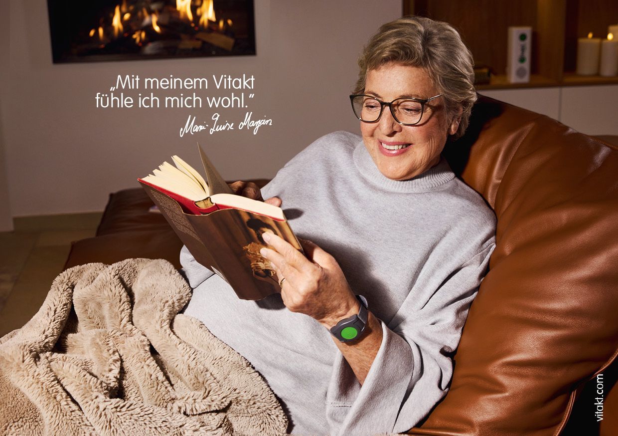 Frau liest lächelnd auf dem Sofa. Zitat über das Wohlgefühl am Kamin.