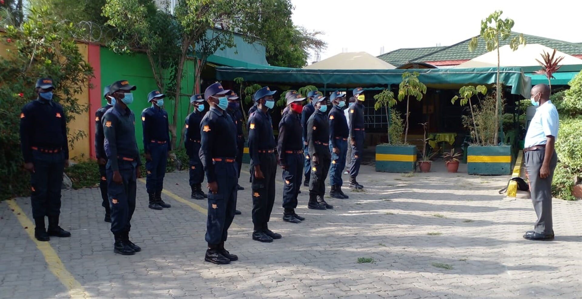 A man is standing in front of a group of soldiers wearing masks.