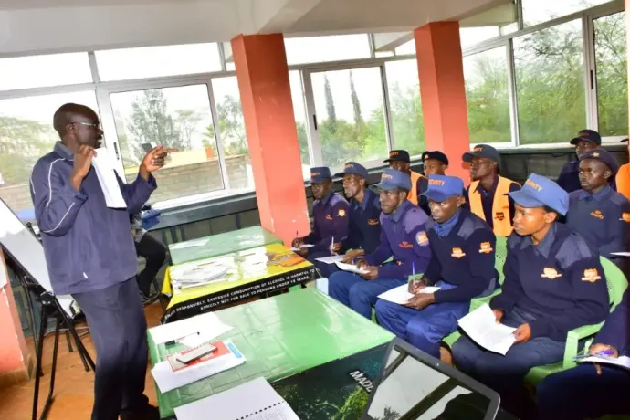 A man is giving a presentation to a group of people sitting at tables.