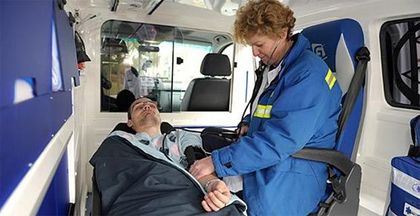 Un ambulancier examine un patient à l'intérieur d'une ambulance.