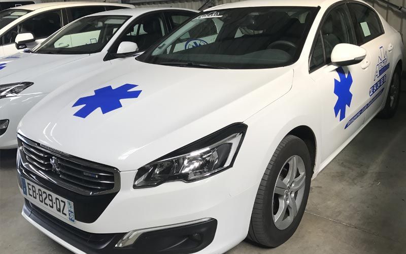 Voitures blanches avec des symboles d'étoile bleue pour les urgences.