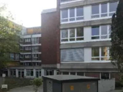 Ein großes Gebäude mit vielen Fenstern und einer Garage davor.