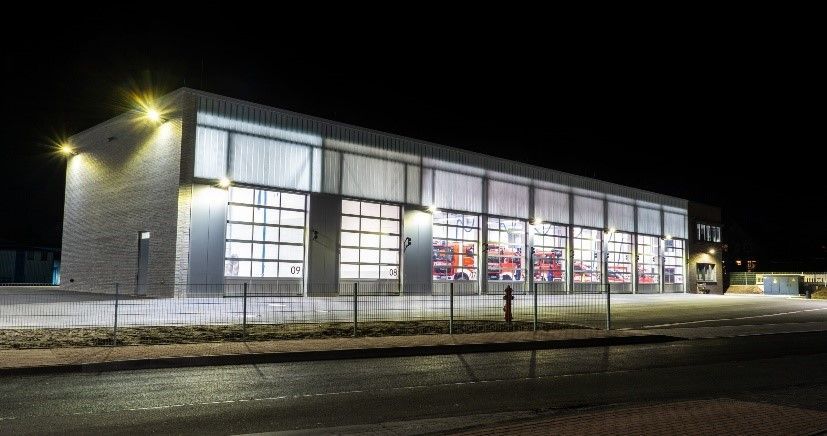 Ein großes Gebäude mit vielen Fenstern ist nachts beleuchtet.