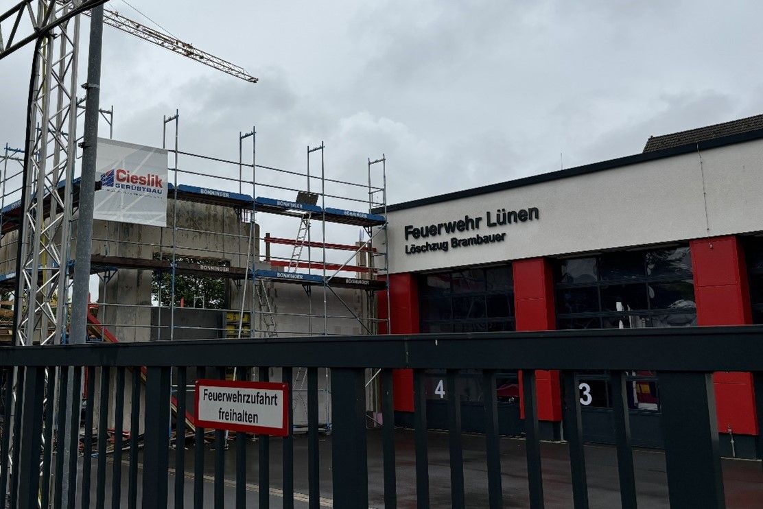 Ein im Bau befindliches Gebäude mit einem Zaun davor.