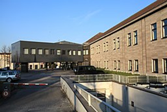 Ein großes Gebäude mit davor geparkten Autos.