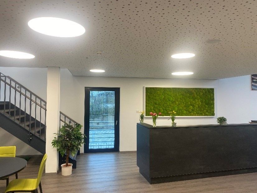 Ein Empfangsbereich mit Treppe und Tisch und Stühlen.