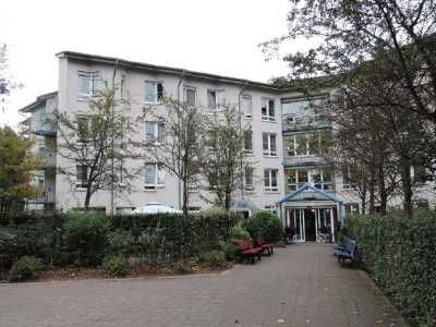 Ein großes rot-weißes Gebäude mit einem davor geparkten Auto.