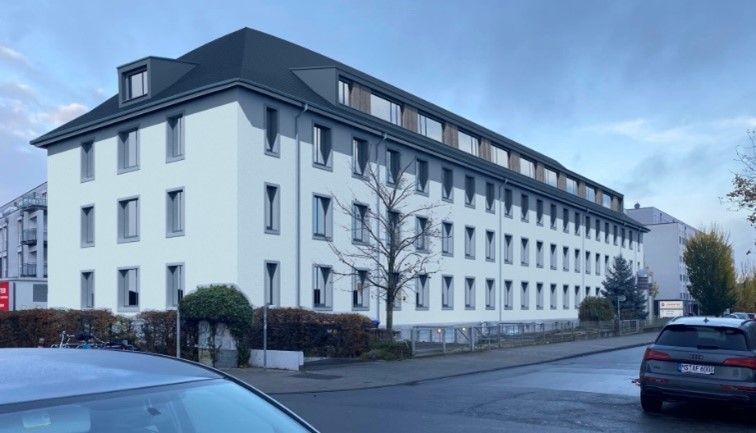 Ein großes weißes Gebäude mit einem davor geparkten Auto.