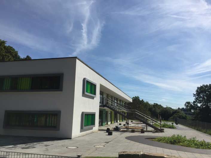 Ein großes weißes Gebäude mit grünen Fenstern und Treppen.