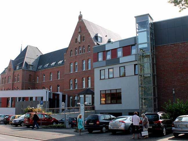 Ein großes Backsteingebäude mit davor geparkten Autos.