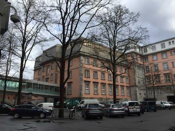 Ein großes Gebäude mit davor geparkten Autos.