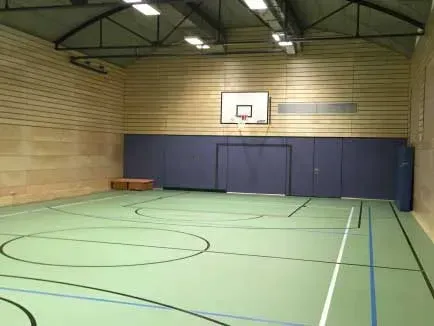 Ein leerer Basketballplatz mit einem Basketballkorb an der Wand.