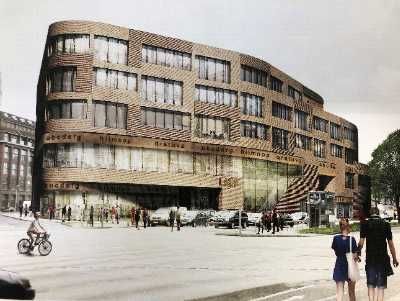 Ein großes Backsteingebäude mit einem Uhrenturm und einer Statue eines Mannes auf einem Pferd davor.