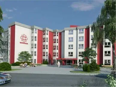 Ein großes rot-weißes Gebäude mit einem davor geparkten Auto.