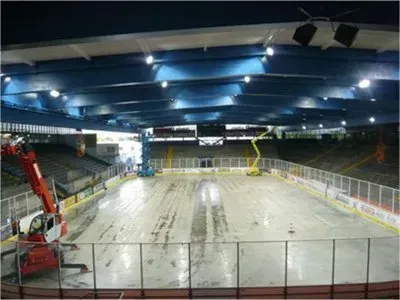 Eine leere Eisbahn mit einem Kran im Hintergrund.