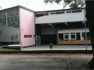 Ein rosa-weißes Gebäude mit vielen Fenstern.