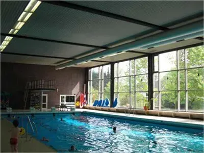 Ein großes Hallenbad mit vielen Fenstern.