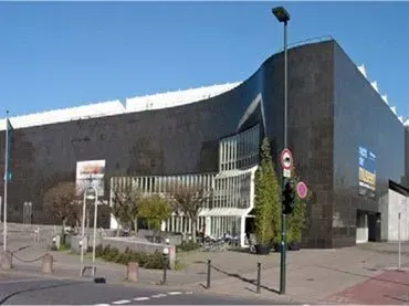 Ein großes Gebäude mit vielen Fenstern und einer Straßenlaterne davor.