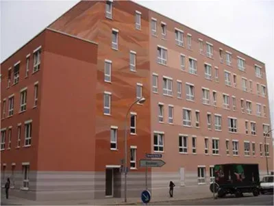 Ein großes Backsteingebäude mit einem davor geparkten Lastwagen.