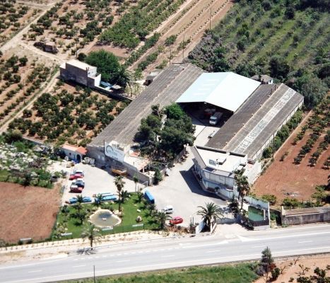 Una vista aérea de un gran edificio rodeado de campos.