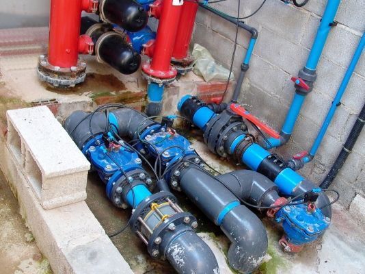 Un montón de tuberías y válvulas están tiradas en el suelo.