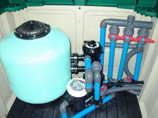 Un cobertizo con un tanque y tuberías en su interior.