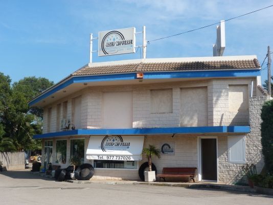 Un edificio blanco con techo azul tiene un cartel en la parte superior que dice
