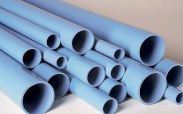 Un montón de tubos azules están apilados uno encima del otro sobre una mesa.