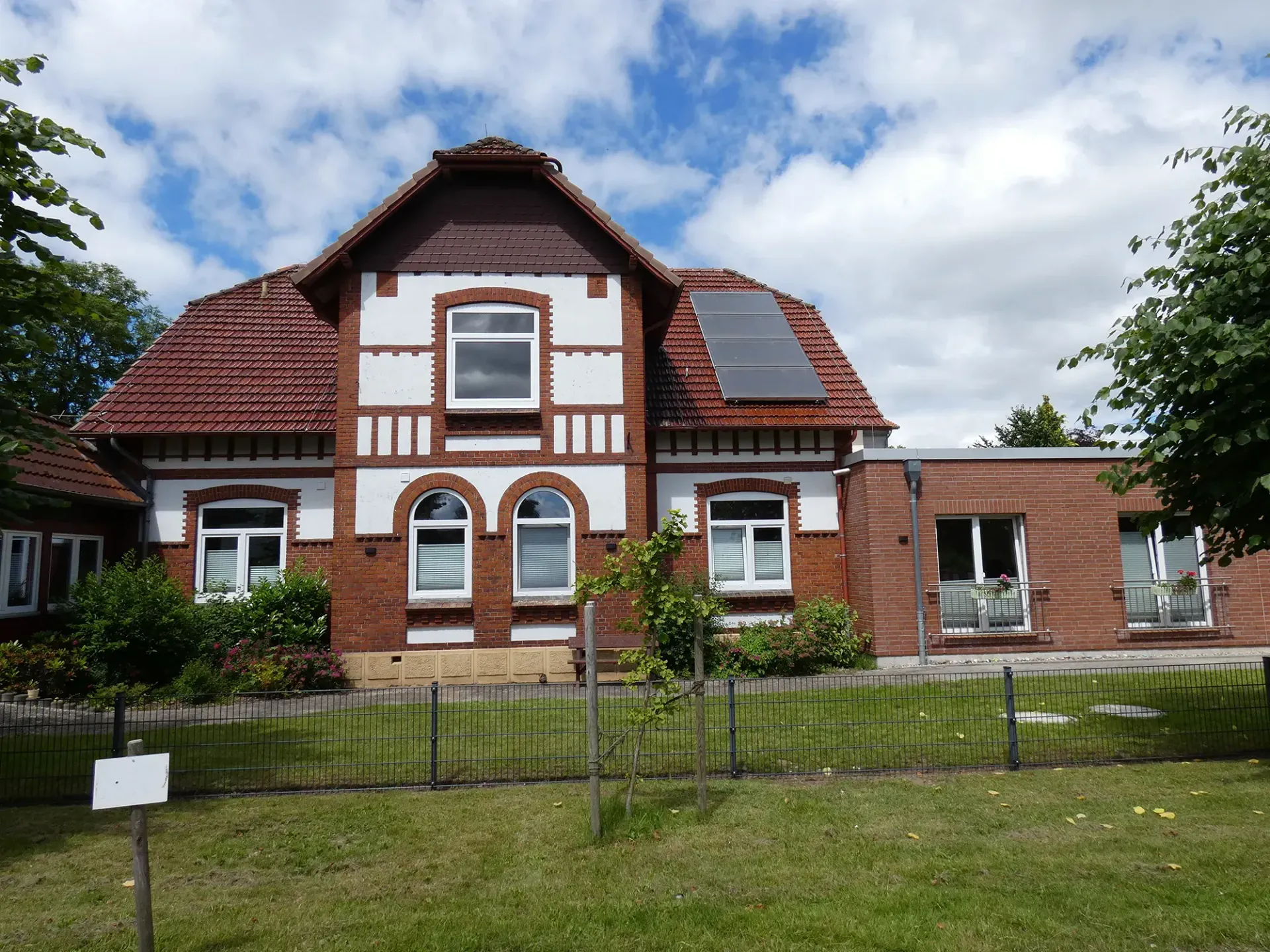 Ein großes Backsteinhaus mit Sonnenkollektoren auf dem Dach